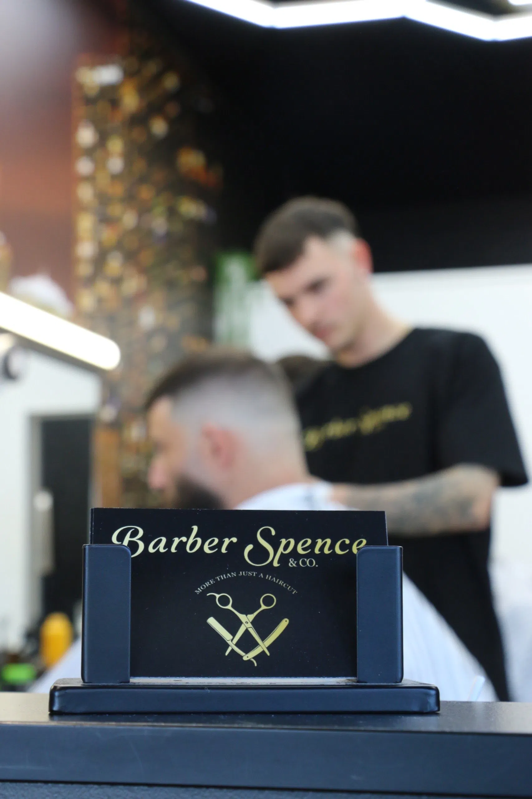 A barber at work inside Barber Spence and Co.